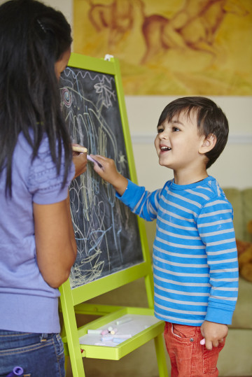 Mum and boy drawing on blackboard