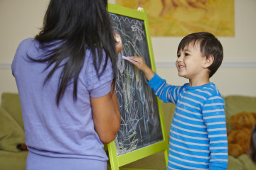 Mum and boy drawing on blackboard