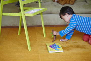 Boy playing with a toy dinosaur