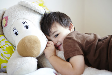 Boy cuddling a teddy