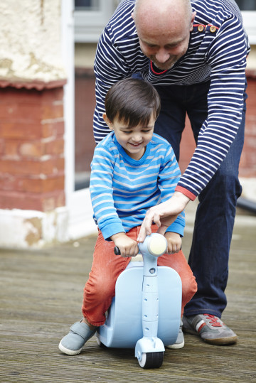 Dad playing with boy on scooter