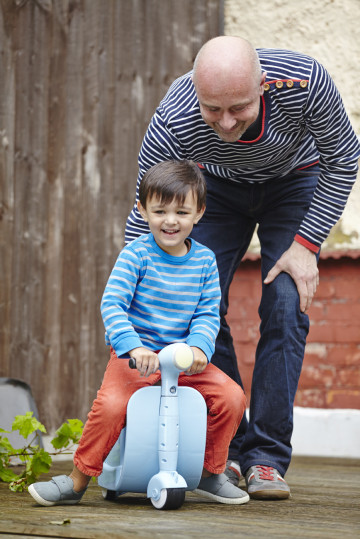 Dad playing with boy on scooter