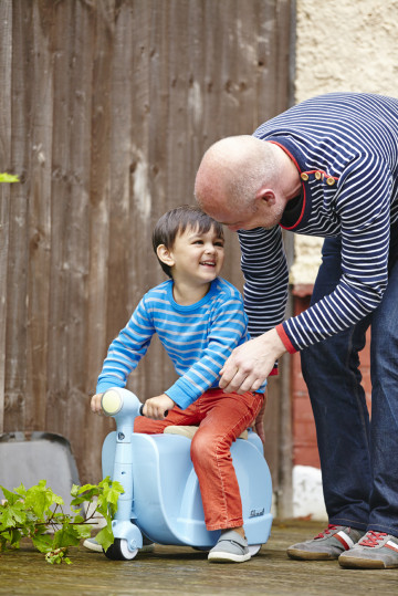 Dad playing with boy on scooter