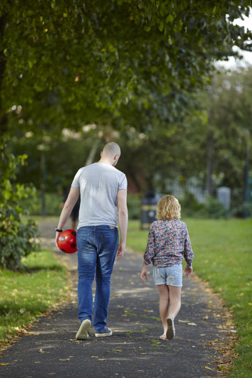 Dad and daughter walking through the park