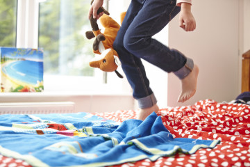 Girl jumping on a bed