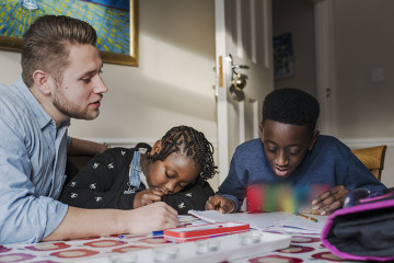 Dad helping son and daughter with homework