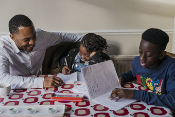 Dad helping son and daughter with homework