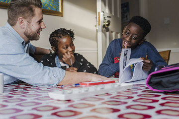 Dad helping son and daughter with homework