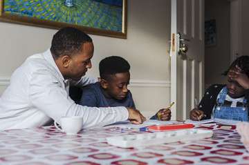 Dad helping son and daughter with homework