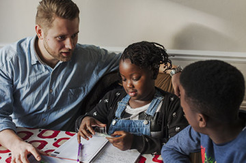 Dad helping son and daughter with homework