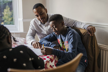 Dad helping son and daughter with homework