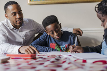 Dad helping son and daughter with homework