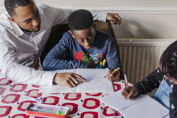 Dad helping son and daughter with homework