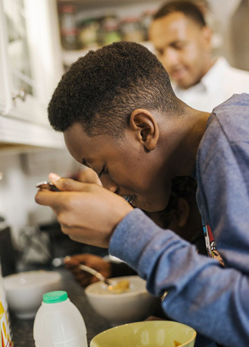 Boy in kitchen eating breakfast