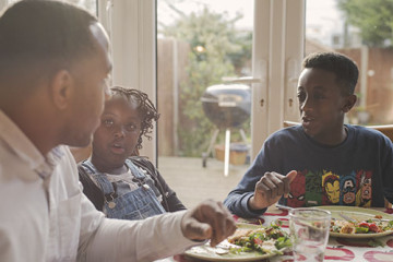 Dad with son and daughter eating at the table