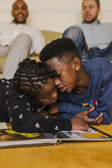 Same sex couple with son and daughter reading