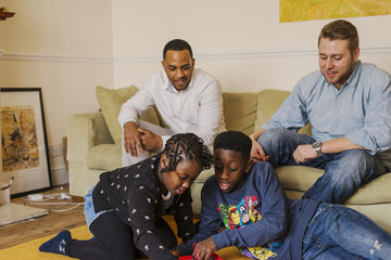 Same sex couple with son and daughter reading