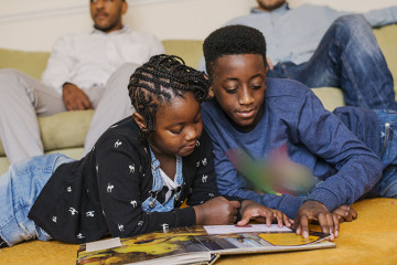 Same sex couple with son and daughter reading