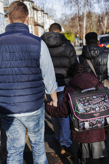 Same sex couple with son and daughter walking to school