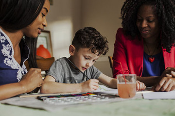 Same sex couple with son painting