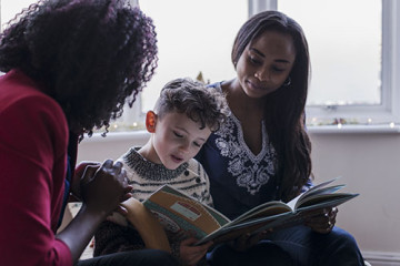 Same sex couple with son reading