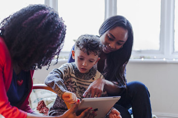 Same sex couple with son reading