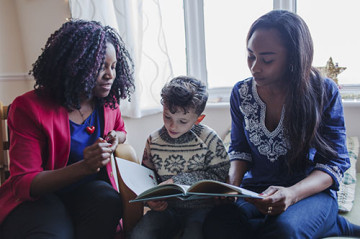 Same sex couple with son reading