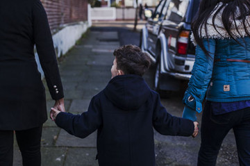 Same sex couple with son walking to school