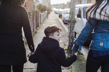 Same sex couple with son walking to school