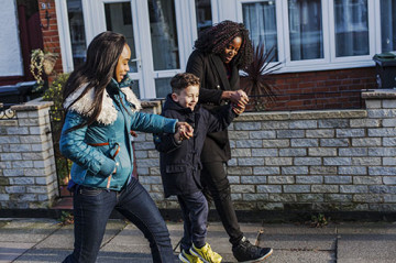 Same sex couple with son walking to school