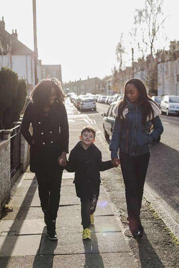 Same sex couple with son walking to school