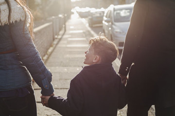 Same sex couple with son walking to school