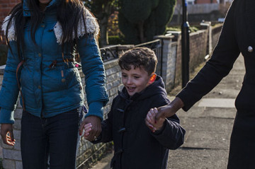 Same sex couple with son walking to school