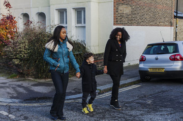 Same sex couple with son walking to school