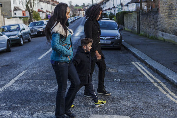 Same sex couple with son walking to school