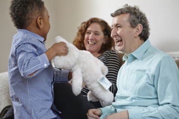 Dad and Mum with son playing with cuddly toy