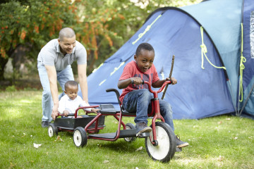 Dad pushing siblings on go cart