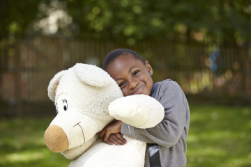 Boy snuggles teddy