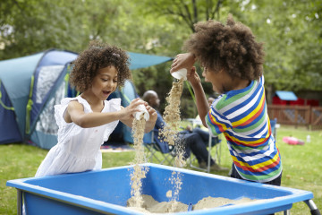 Siblings playing in sand pit