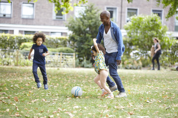 Father, son and daughter playing football