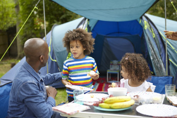 Father, son and daughter enjoying picnic