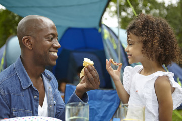 Dad and daughter sharing a snack