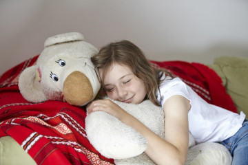 Girl snoozing with teddy bear