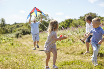 Family playing together with kite