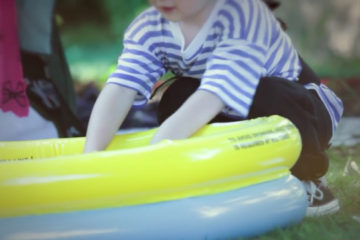 Boy dressed as pirate next to paddling pool at Adoption Activity Day